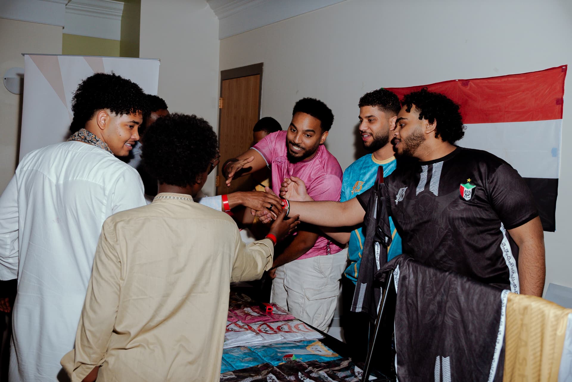 Students greeting each other at the Taste of Sudan welcome table