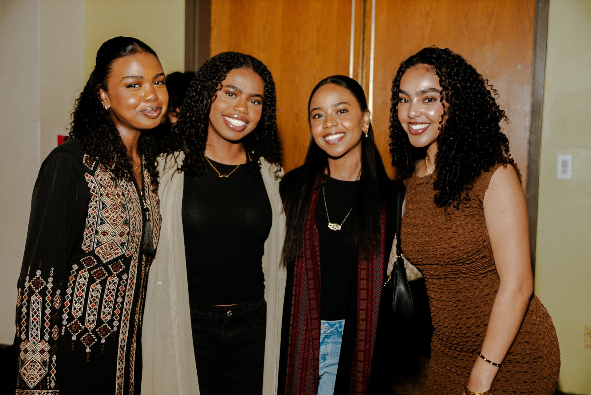 Four students smiling together at Taste of Sudan